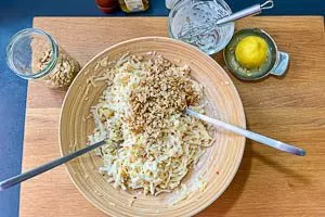 Sellerie- und Apfelraspel mit dem Dressing vermengen und abschmecken