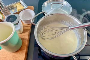 Mit Milch aufgießen und köcheln lassen.