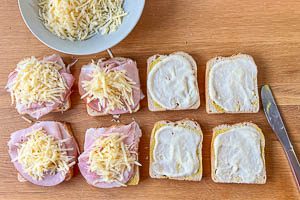 Mit Béchamelsauce, Schinken und Käse belegen.