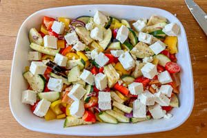Geschnittene Oliven und Feta über dem Gemüse verteilen