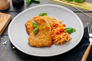 Spaghetti mit Tomatensoße und Kalbsschnitzel servieren. Fertig ist deine Piccata Milanese!
