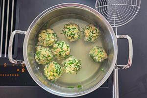 Knödel in einem hohen Topf in Wasser kochen
