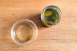 Gurkenwasser in eine Schüssel abfüllen