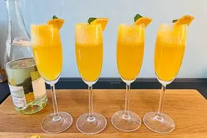 Mit Schaumwein aufgießen und mit Minze und Orange dekorieren.