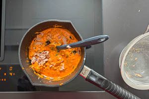 Thunfisch und Oliven zu der Soße geben