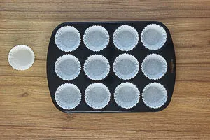 Muffinblech mit Papierförmchen bestücken