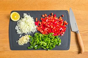 Knoblauch, Zwiebeln und Paprika würfeln