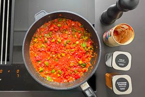 Stückige Tomaten, Salz, Pfeffer und Cayennepfeffer hinzugeben