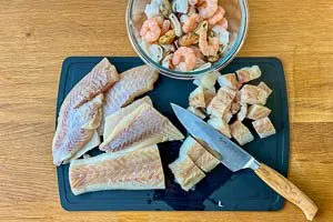 Meeresfr&uuml;chte bereitstellen, Fisch trockentupfen und in W&uuml;rfel schneiden