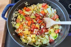 Gem&uuml;se und Tomatenmark dazugeben und mitr&ouml;sten