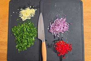 Petersilie waschen, trocknen und schneiden, rote Zwiebeln und Knoblauch schälen und fein würfeln, rote Peperoni fein würfeln