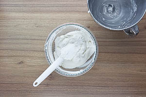 Steif geschlagene Sahne unter die Frischkäse-Creme heben