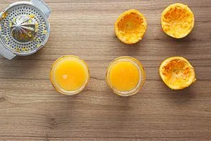 Den Orangensaft in zwei Gläser geben.