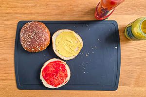 Buns erw&auml;rmen, zerschneiden, eine Seite mit Ketchup und eine Seite mit Senf bestreichen