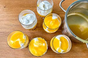 Fruchtpudding und Creme abwechselnd in die Dessertgläser schichten
