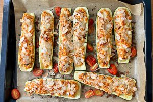 &Uuml;berbackene Zucchinih&auml;lften aus dem Backofen holen