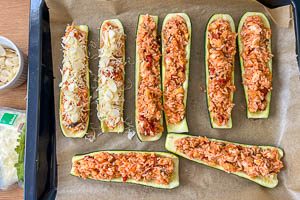 Zucchinih&auml;lften bef&uuml;llen und K&auml;se dar&uuml;berstreuen