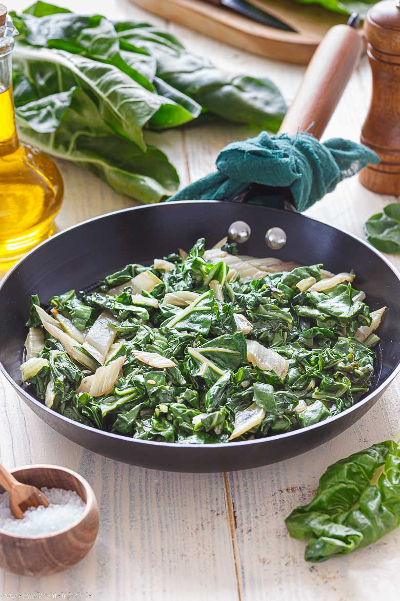 Mangold mit Olivenöl, Knoblauch und Gemüsebrühe in der Pfanne dünsten