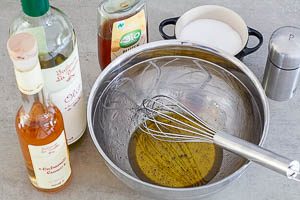 Das Dressing für den Tomatensalat aus Öl, Essig, Honig, Salz und Pfeffer anrühren.